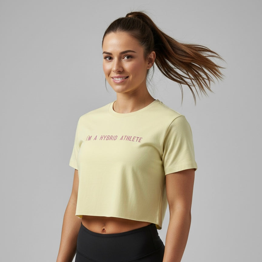 Atleta híbrida mujer con camiseta Crop Top Hybrid Athlete crema crosstraining HYROX DEKA ropa deportiva calle
