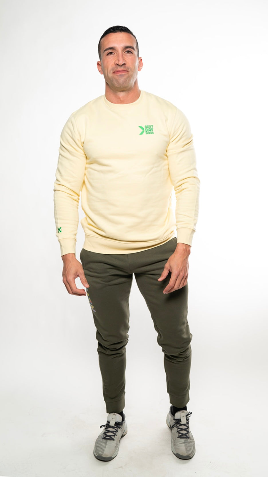 modelo con sudadera Rest Day Sucks amarilla y pantalón camo de XHEN