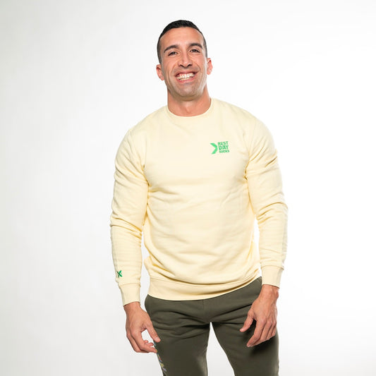 Modelo con sudadera Rest Day Sucks amarilla de XHEN en posición de descanso